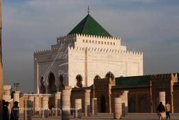 Image du Maroc Professionnelle de  Le tombeau du plus populaire des sultans du Maroc, Mohammed V, père de l’indépendance repose ici dans cette  demeure bâtie en marbre blanc et couronnée par un toit pyramidale orna de tuiles vertes, symbole de la royauté. Sa construction a nécessita une dizaine d’année, au premier plan  les colonnes de l’esplanade de la Mosquée Hassan à Rabat, Jeudi 1er Mars 2007. (Photo / Abdeljalil Bounhar)
